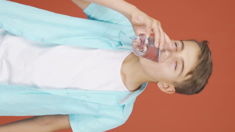 Vertical-video-of-The-boy-is-drinking-water.
